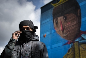 Image of artist Sens in front of his piece "The Migrant Prince".